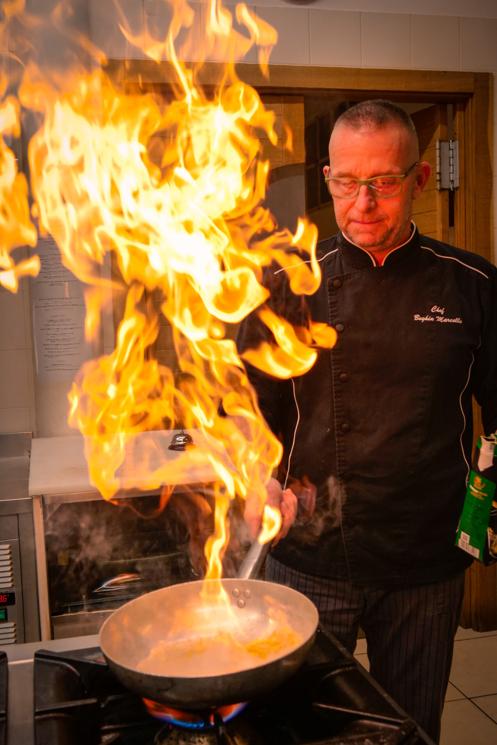 Lo chef del Terra del Mezzo prepara un piatto flambé in padella