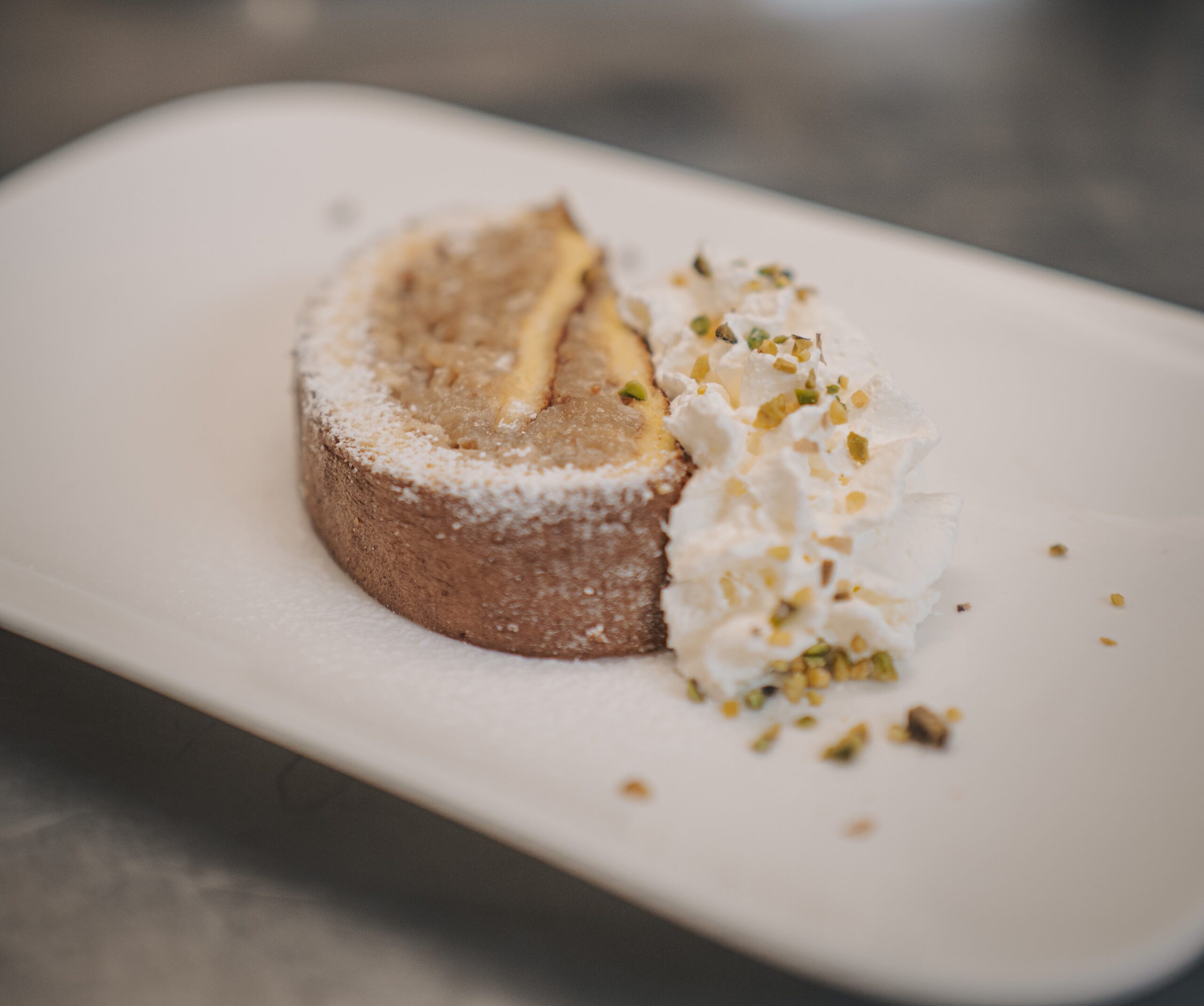Dolce al piatto con panna montata e granella di pistacchio