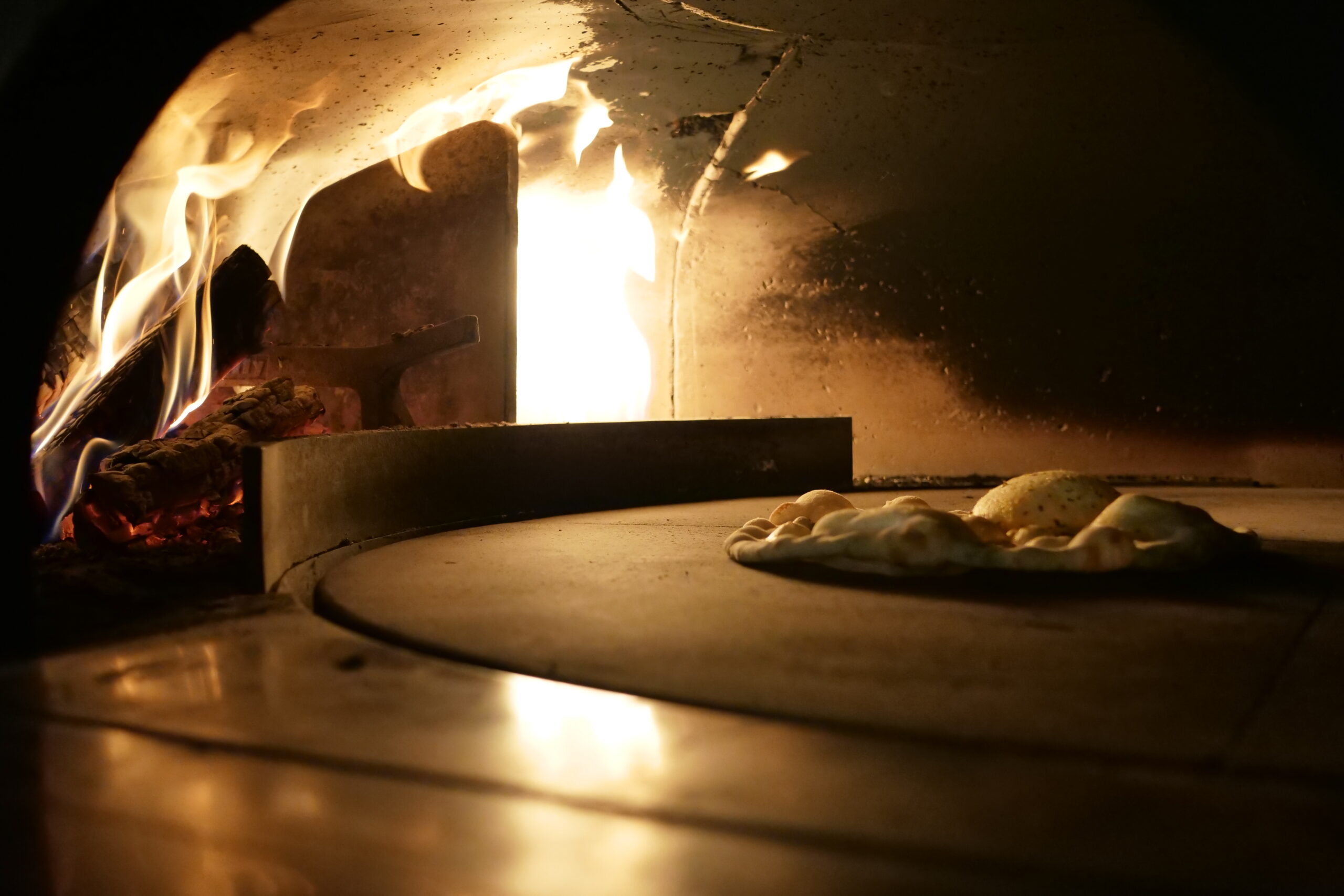 Forno a legna della pizzeria con pizze in cottura