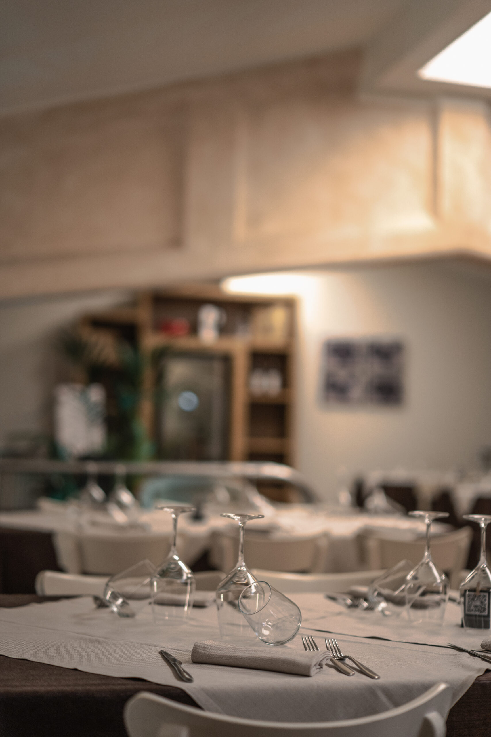 Sala del ristorante apparecchiata con tovaglie bianche e calici