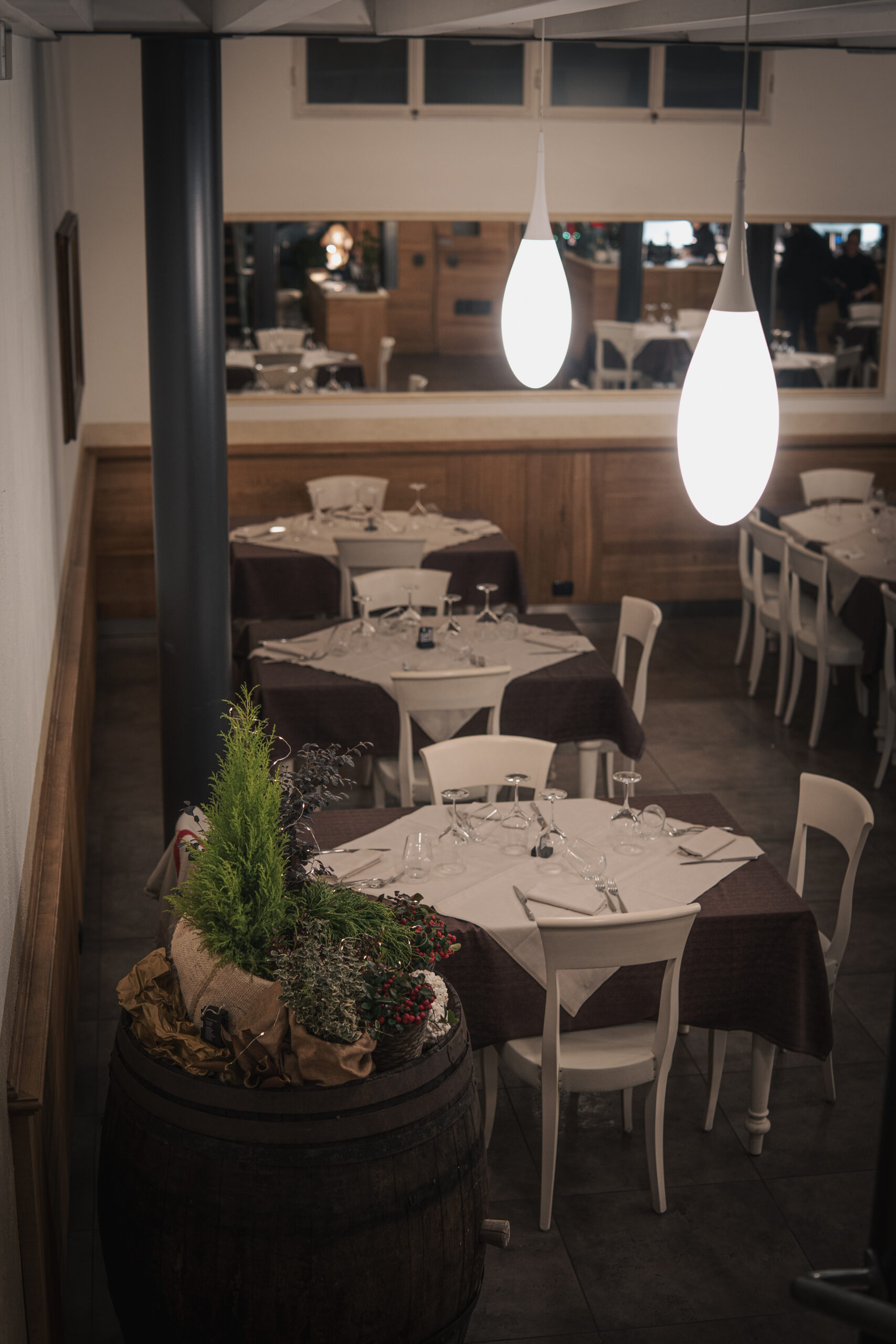 Sala da pranzo con tavoli apparecchiati e botte decorativa